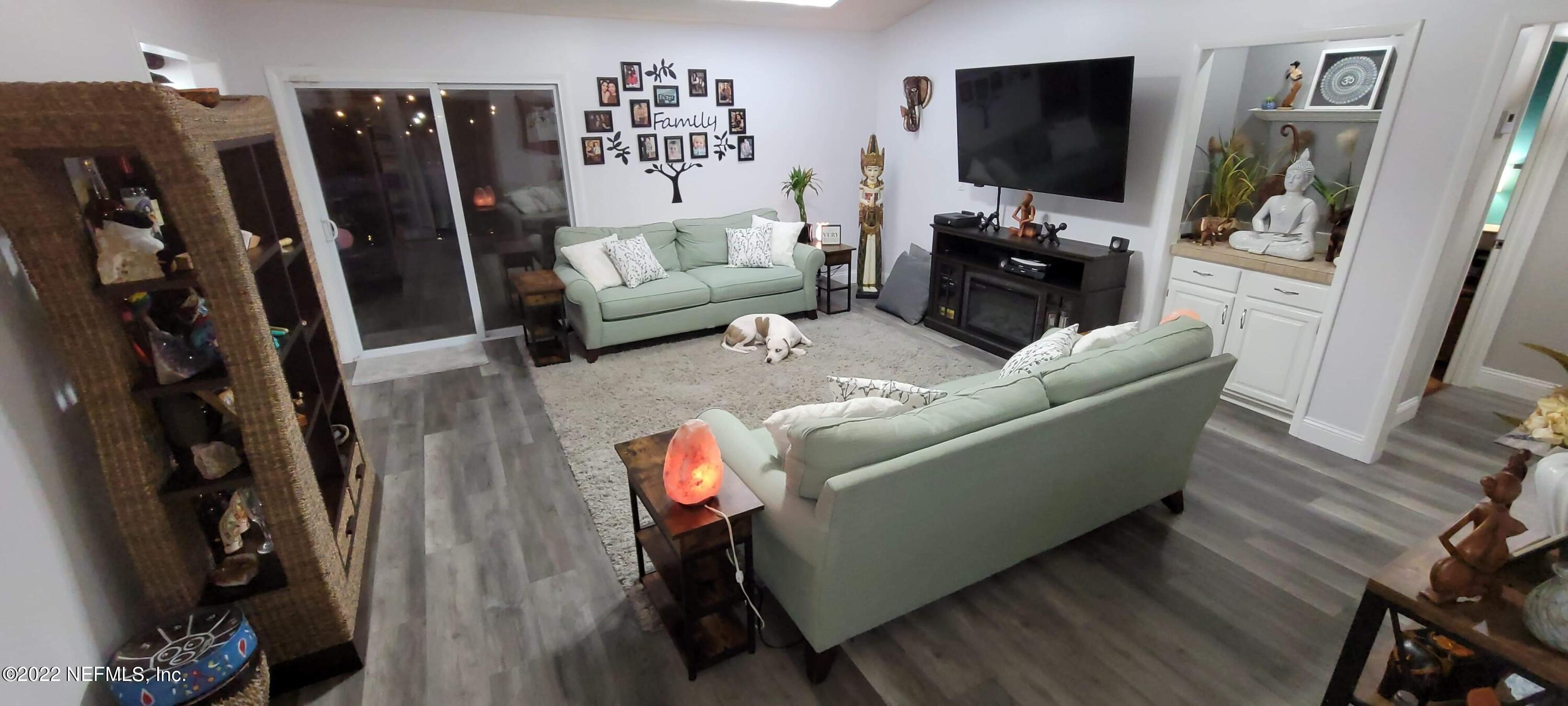 6044 West Shores Road Fleming Island, FL 32003 - Photo 6 of 18 a living room with furniture and a flat screen tv