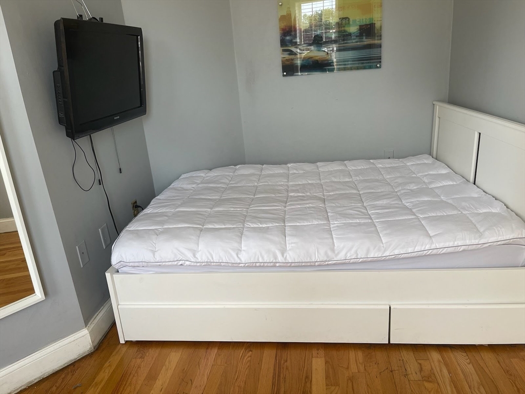 102 Moreland Street Boston, MA 02119 - Photo 12 of 31 a bedroom with a bed and flat screen tv
