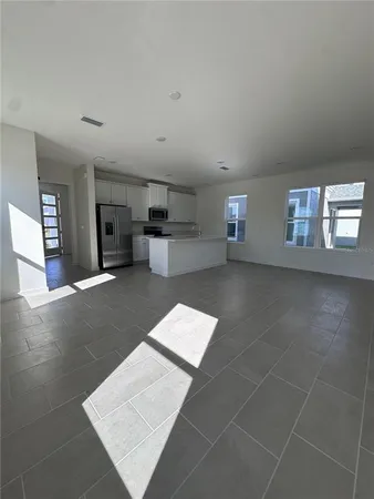 a large white kitchen with cabinets and a refrigerator