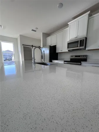 a kitchen with granite countertop a refrigerator and a sink