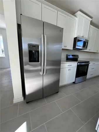a view of kitchen with furniture and refrigerator