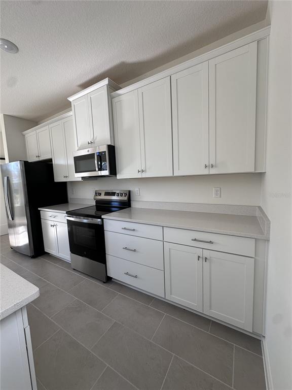 2059 Iorio Street St. Cloud, FL 34771 - Photo 17 of 61 a kitchen with granite countertop white cabinets and stainless steel appliances