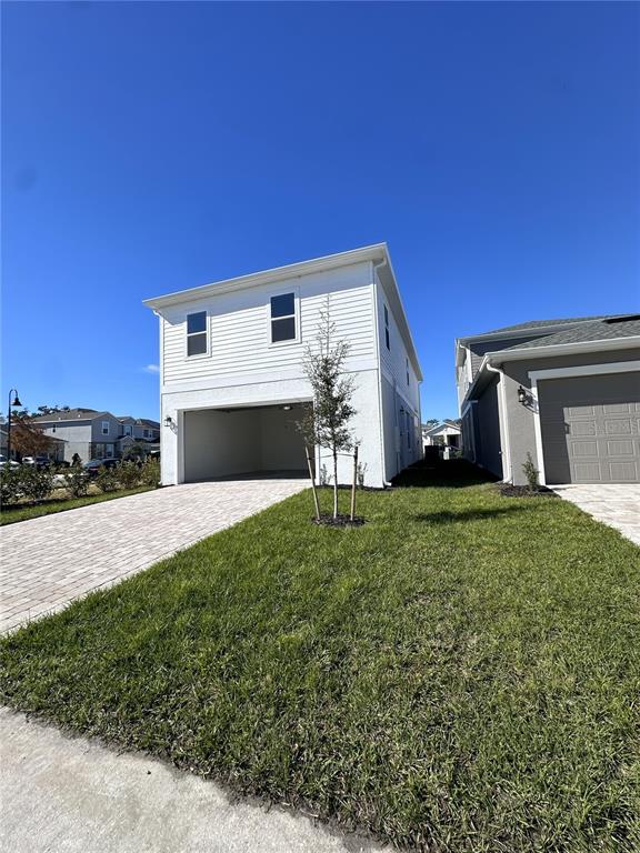 2059 Iorio Street St. Cloud, FL 34771 - Photo 26 of 61 a front view of a house with a yard and garage
