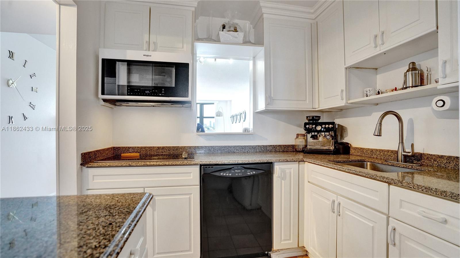 1228 West Avenue, Unit 201 Miami Beach, FL 33139 - Photo 16 of 42 a kitchen with granite countertop white cabinets and white appliances