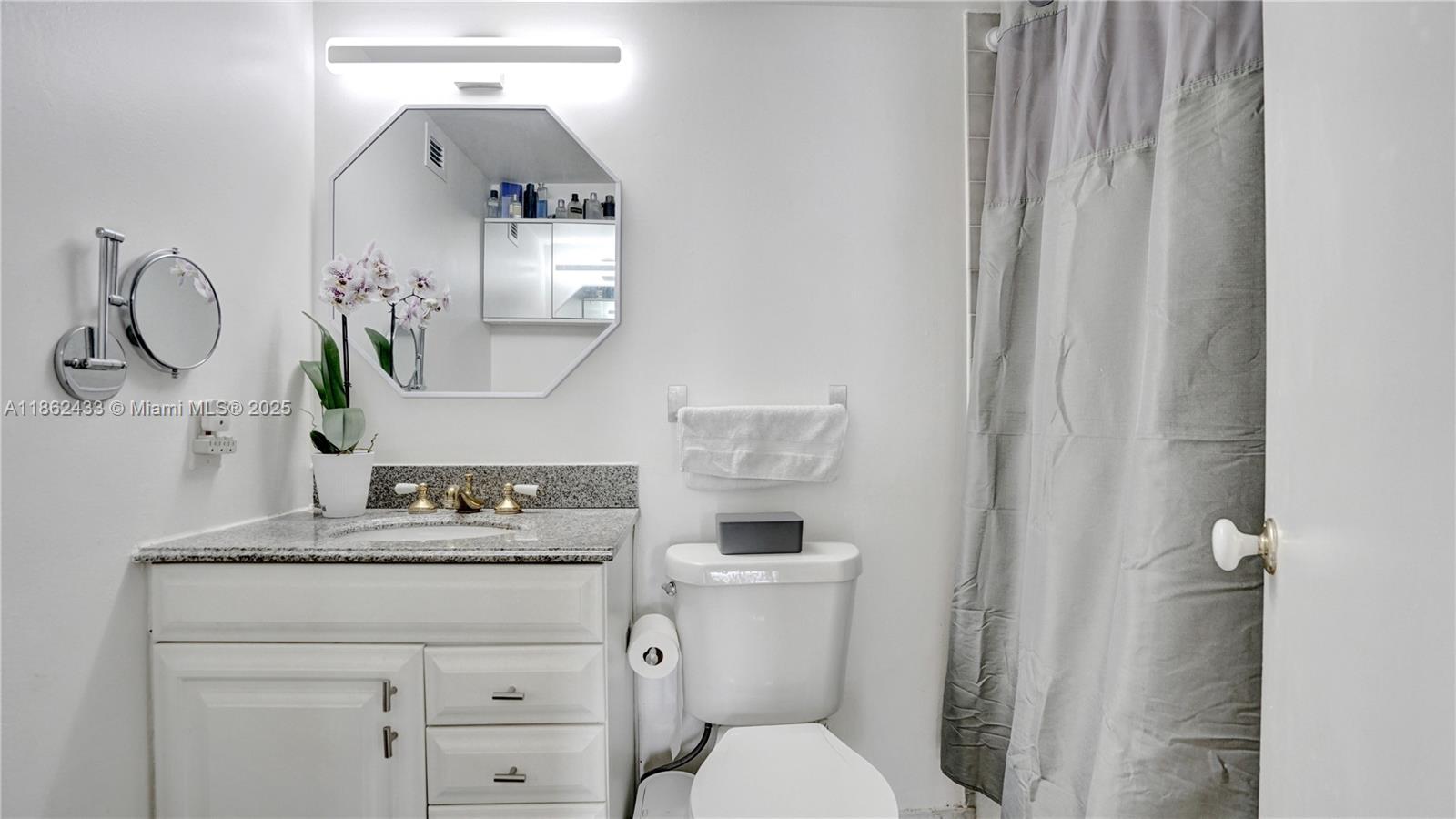 1228 West Avenue, Unit 201 Miami Beach, FL 33139 - Photo 24 of 42 a bathroom with a toilet sink and mirror