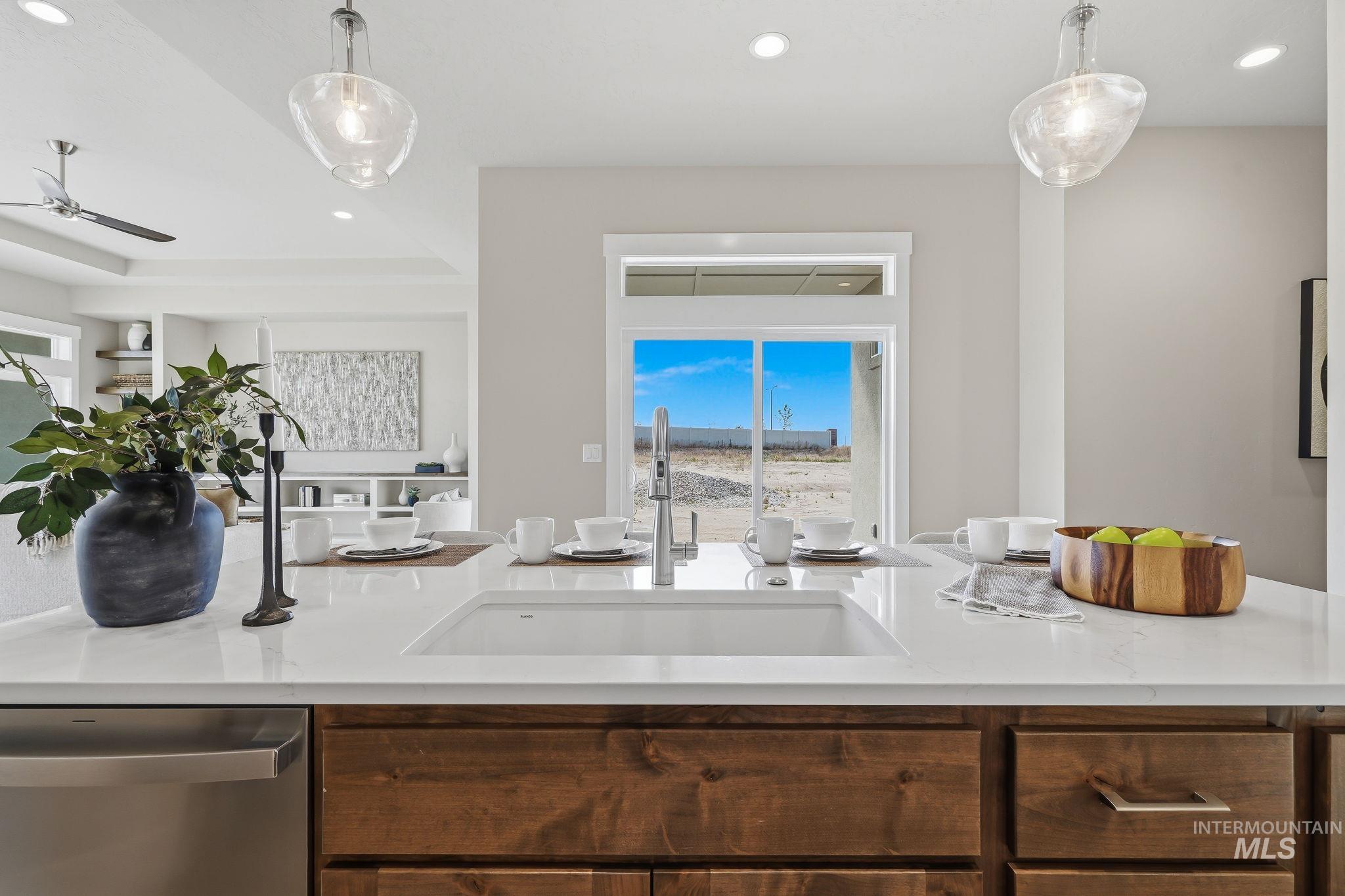 470 South Radiator Way Boise, ID 83716 - Photo 28 of 50 Kitchen island featuring a white undermount sink, a chrome pull-down faucet, and a light-toned countertop
