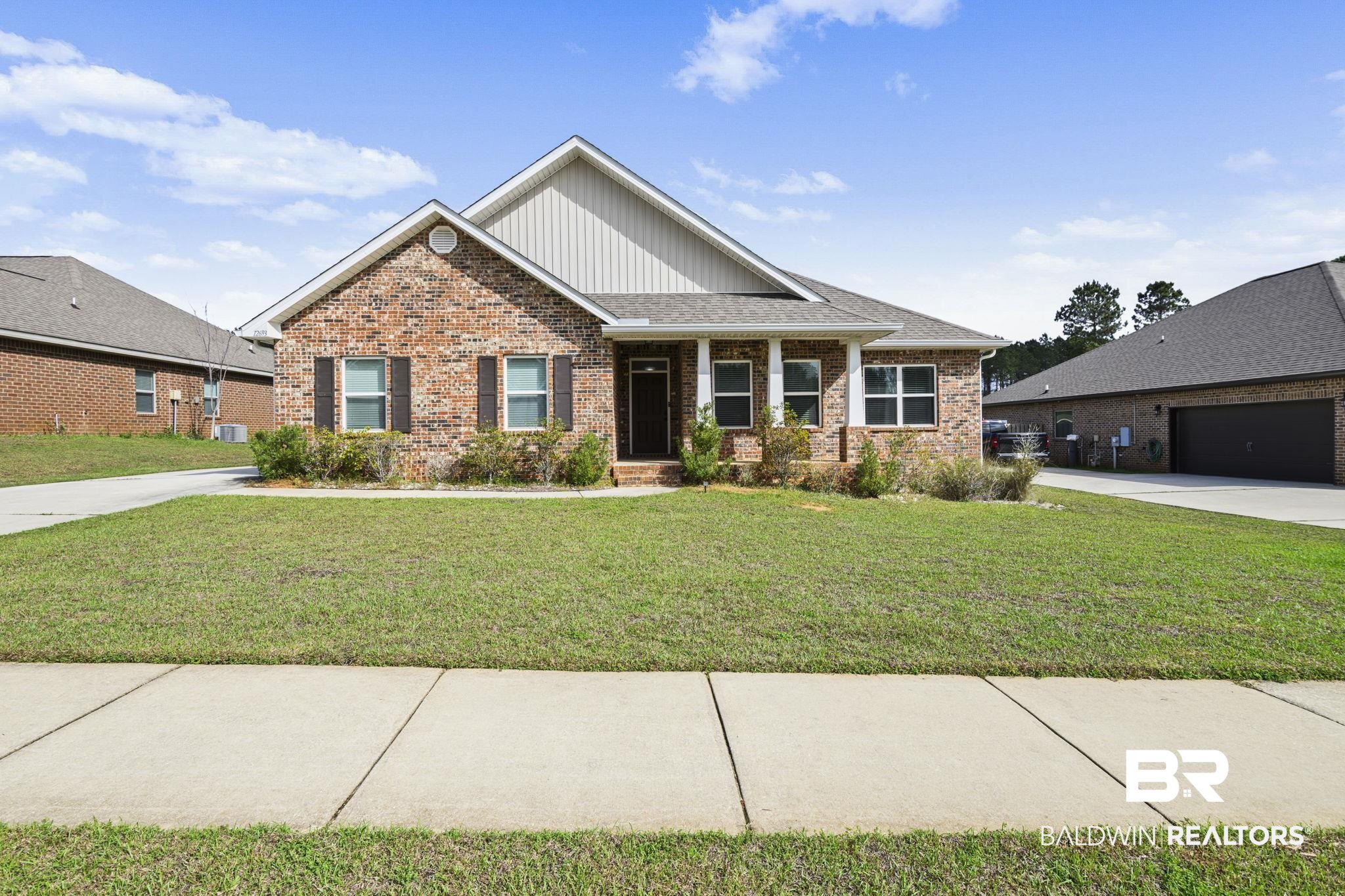 12693 Waxwing Avenue Daphne, AL 36527 - Photo 2 of 43 Craftsman inspired home featuring brick siding, a front yard, a porch, a shingled roof, and board and batten siding