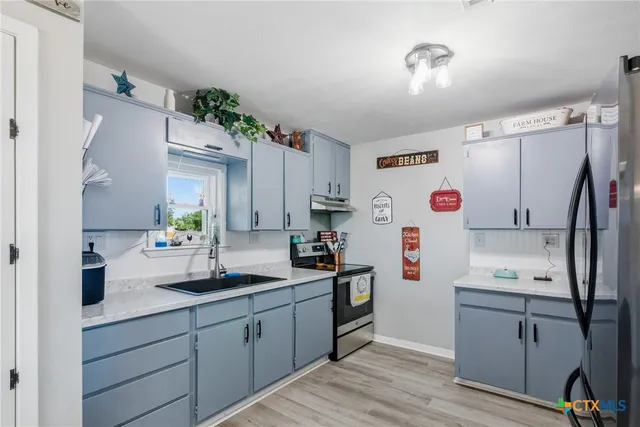 a kitchen with a sink cabinets and wooden floor