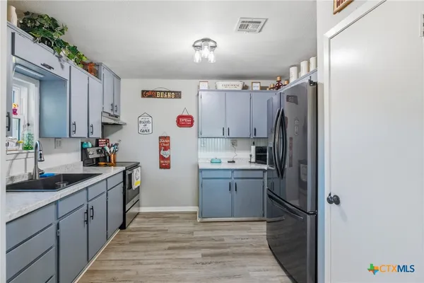 a kitchen with a sink a refrigerator and a stove