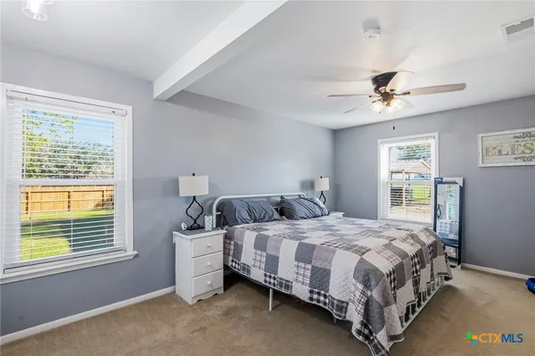 a bedroom with a bed chandelier and a window