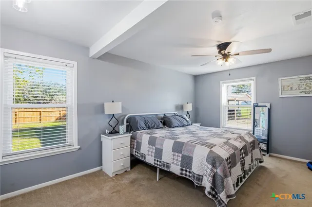 a bedroom with a bed chandelier and a window