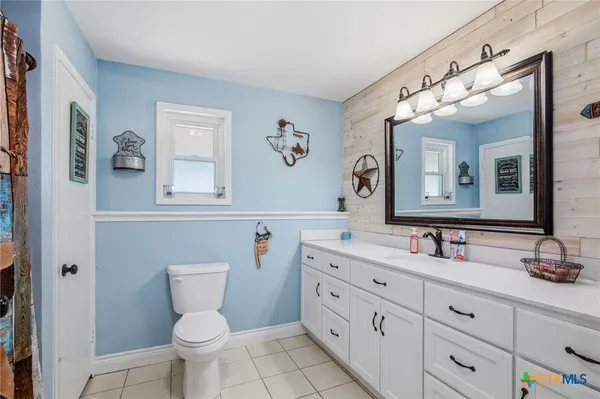 a bathroom with a double vanity sink mirror and toilet
