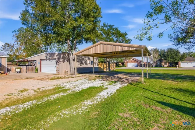 a view of a house with backyard and sitting area