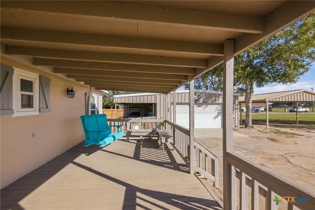 a view of a porch with furniture and a backyard