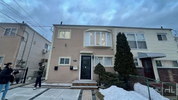 a front view of a house with a tree