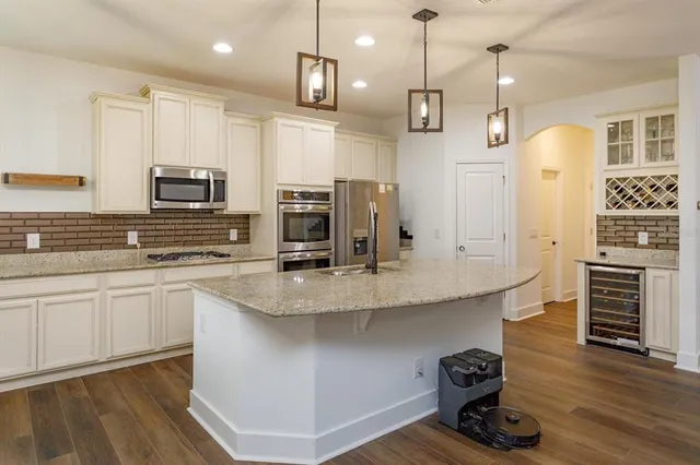 a kitchen with kitchen island a counter top space appliances and cabinets