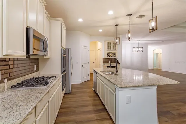 a kitchen with stainless steel appliances granite countertop a sink stove and refrigerator