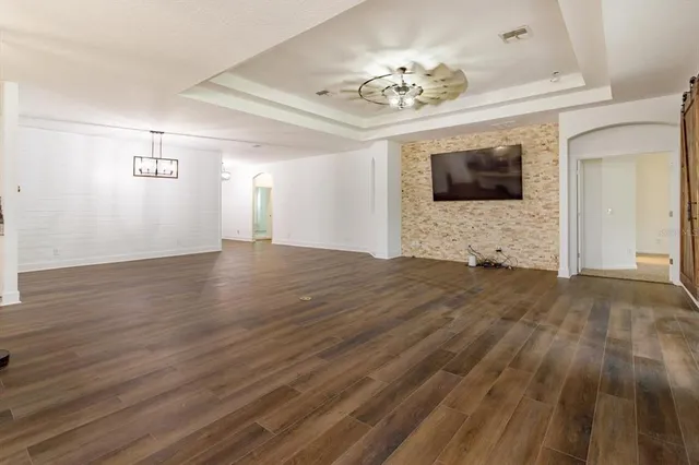 a view of an empty room with a fireplace and wooden floor