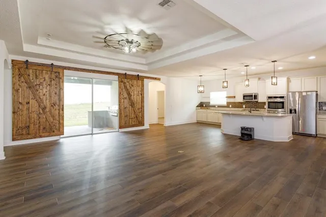 a view of a kitchen with a stove wooden cabinets and a kitchen counter top
