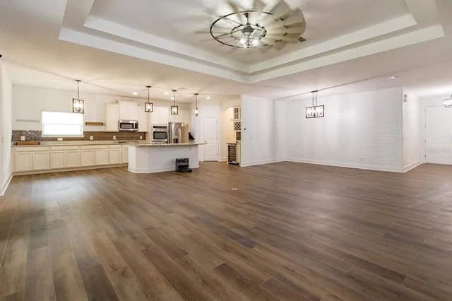 a large kitchen with a wooden floor and cabinets