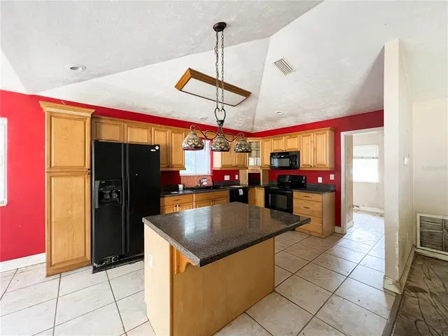 a kitchen with stainless steel appliances granite countertop a refrigerator and a stove top oven