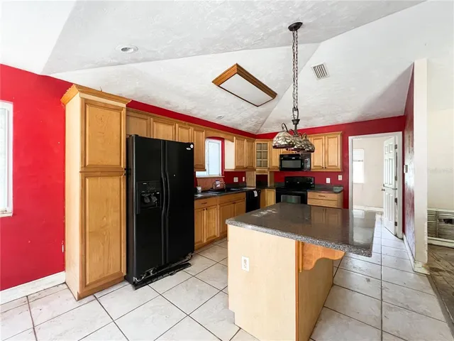 a kitchen with stainless steel appliances granite countertop a refrigerator and a stove