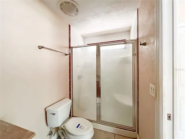 a view of a livingroom with a chandelier fan and windows