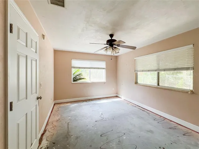 a view of empty room with windows and cabinet