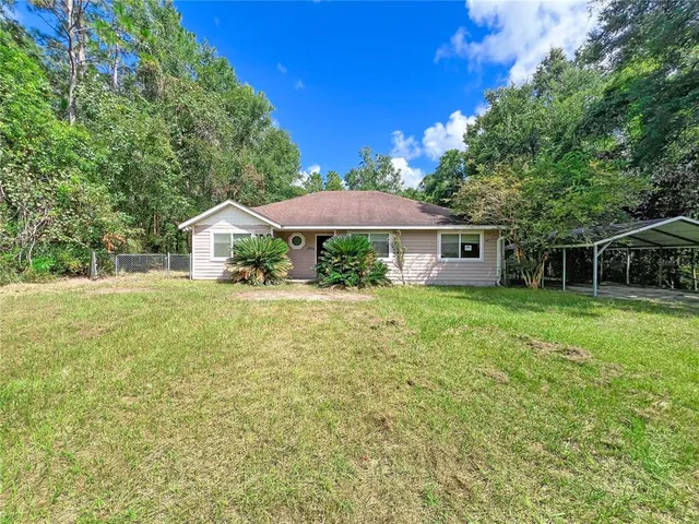 a house with green field in front of it