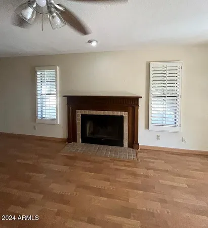 a view of an empty room with a fireplace and a window