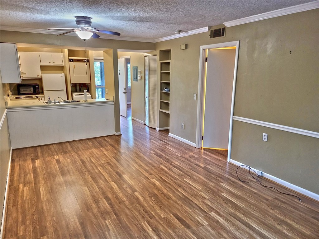 150 Ligon Street, Unit 1001 Clemson, SC 29631 - Photo 5 of 29 Laminate flooring connects the open-concept living area to a compact, well-appointed kitchen.