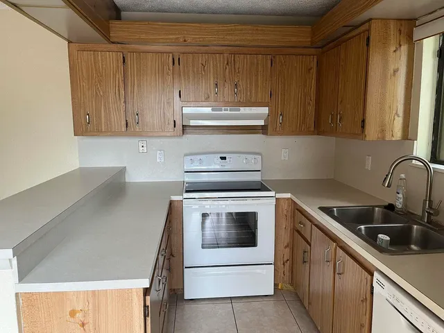 a kitchen with a sink a stove and cabinets