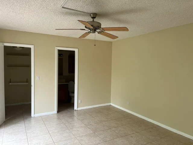 an empty room with a ceiling fan and a window
