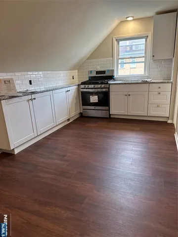 a kitchen with granite countertop white cabinets and white appliances