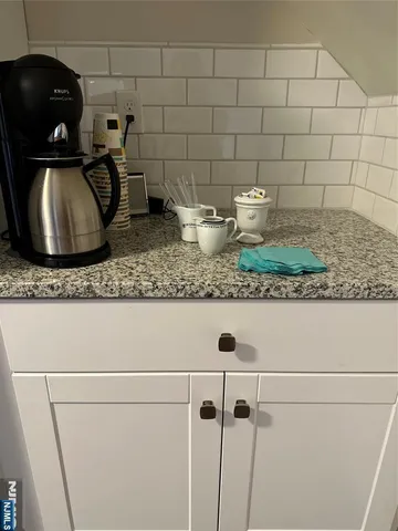 a view of a refrigerator in kitchen and white cabinets