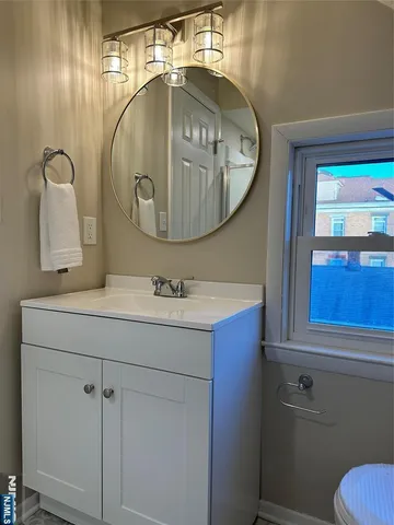 a bathroom with a sink mirror vanity and toilet