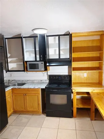 a kitchen with a sink cabinets and wooden floor