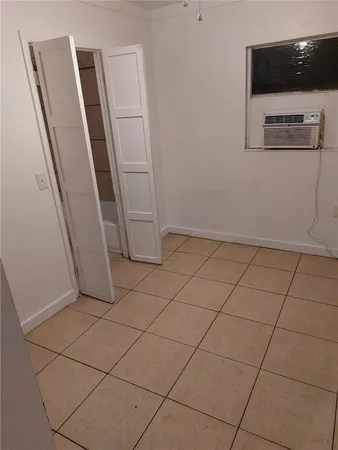 an empty room with wooden floor and cabinet