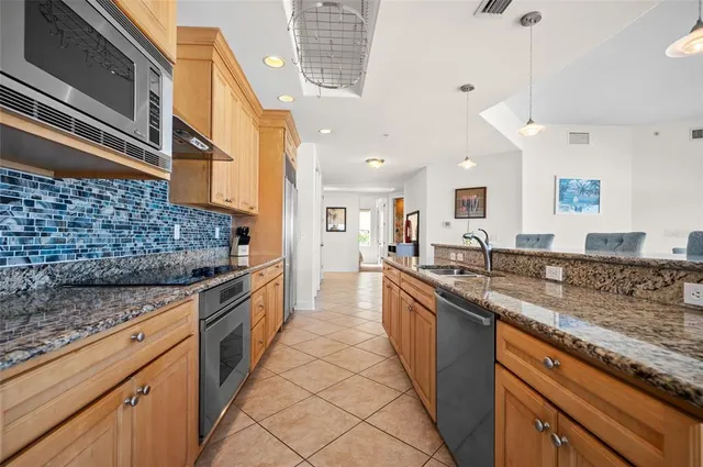 a large kitchen with granite countertop a sink and cabinets