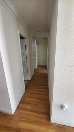 a view of a hallway with wooden floor and entryway