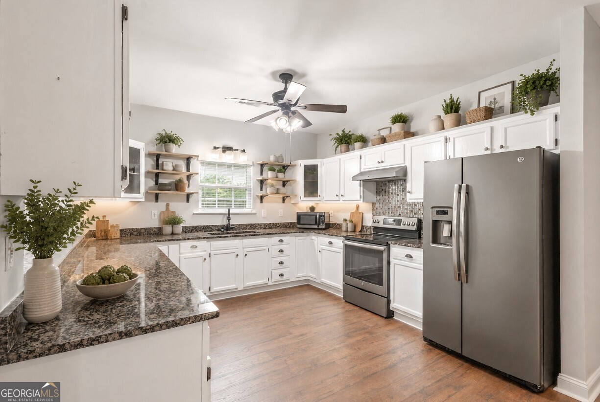 82 Newton Road LaGrange, GA 30240 - Photo 5 of 45 a kitchen with stainless steel appliances granite countertop a refrigerator a sink dishwasher a stove a dining table and chairs with wooden floor