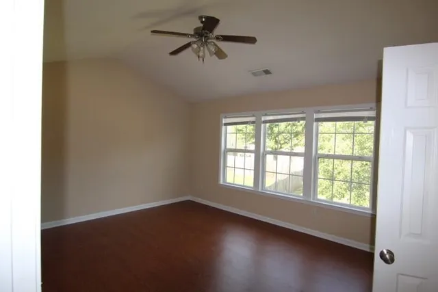an empty room with a window and a fan