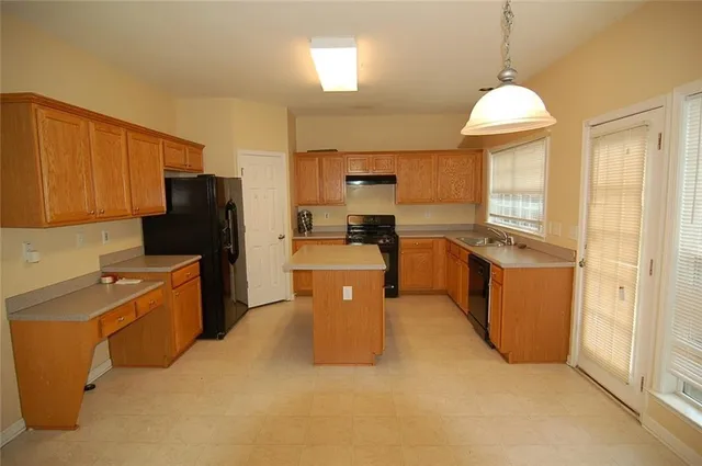 a kitchen with stainless steel appliances granite countertop a stove refrigerator sink and dishwasher