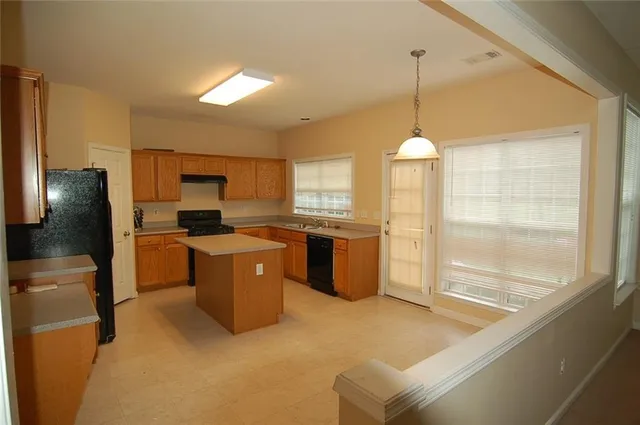 a kitchen with a refrigerator a sink dishwasher with a dining table and chairs