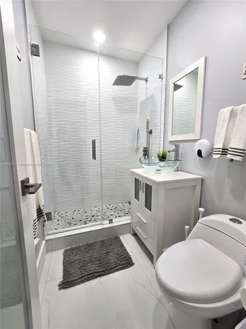 a bathroom with a double sink toilet and shower