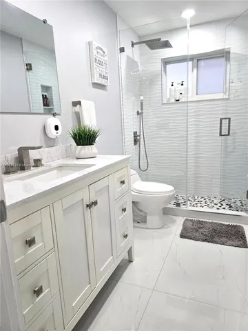 a bathroom with a double vanity sink toilet and shower