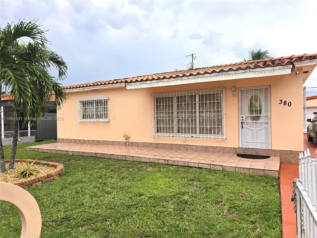 a view of a house with a small yard and wooden fence