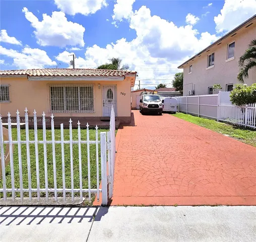 a backyard of a house with table and sofas