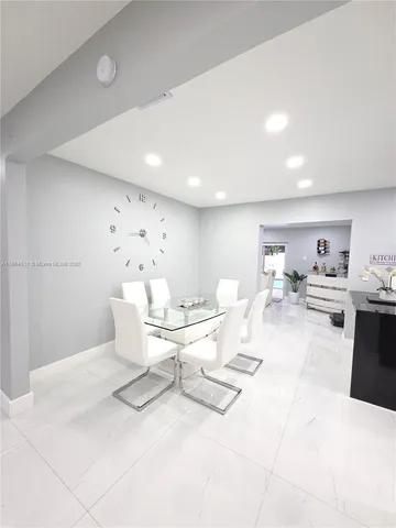 a living room with furniture and view of kitchen
