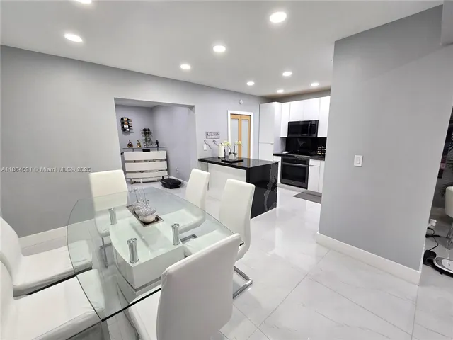 a living room with furniture a flat screen tv and kitchen view